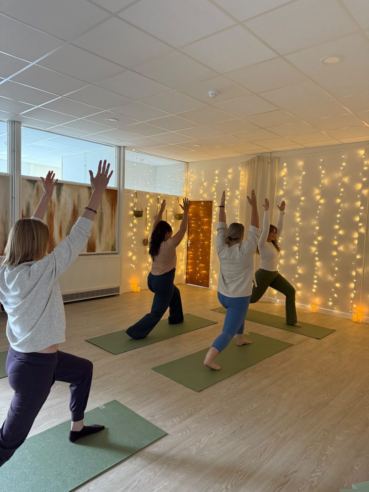A small yoga class moving together in the RESET Ruthin studio