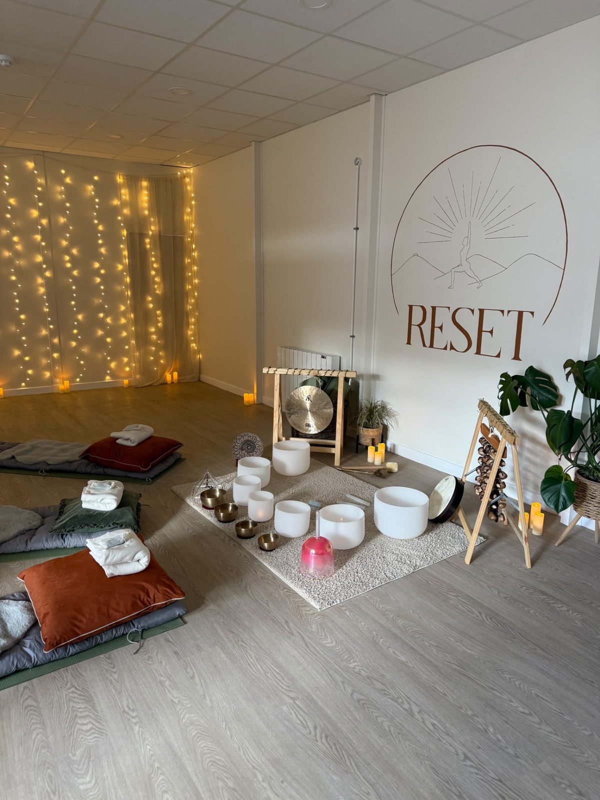 The RESET studio set up with crystal singing bowls, blankets and cushions for a sound bath